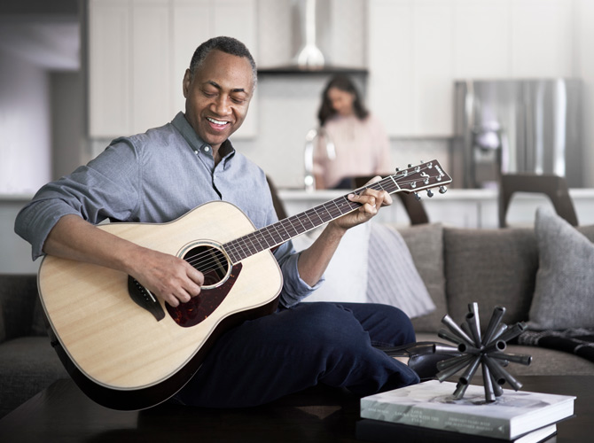 Man playing guitar and smiling