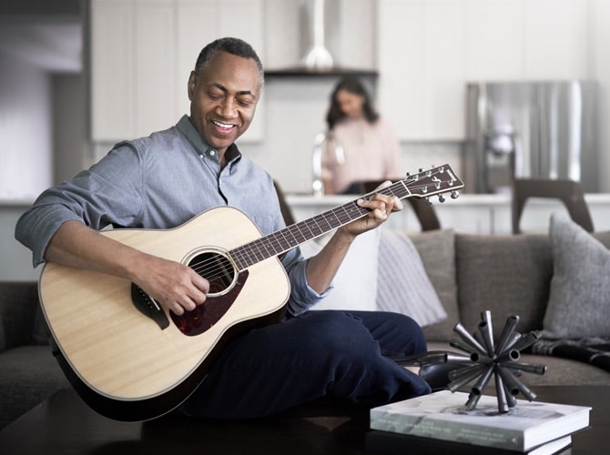 Man playing guitar and smiling